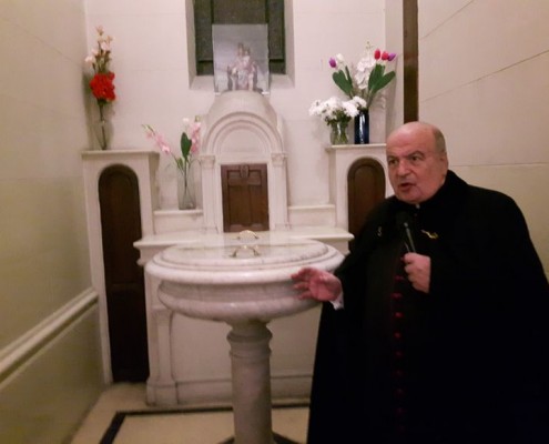 Monseñor Antonio Aloisio junto a la Pila Bautismal.