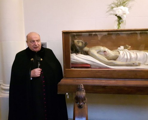 Monseñor Antonio Aloisio, párroco de Santa Julia junto a la imagen del Cristo yacente.