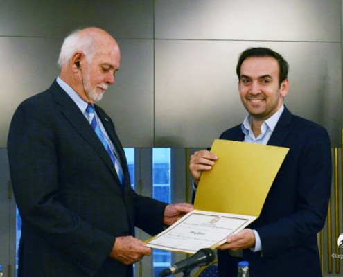 Barry Rassin recibe su diploma de manos de Francisco Quintana, vicepresidente de la Legislatura.