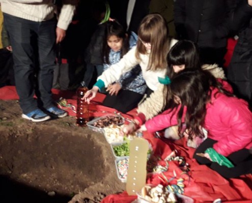 Los chicos arrojan las ofrendas a la Pachamama